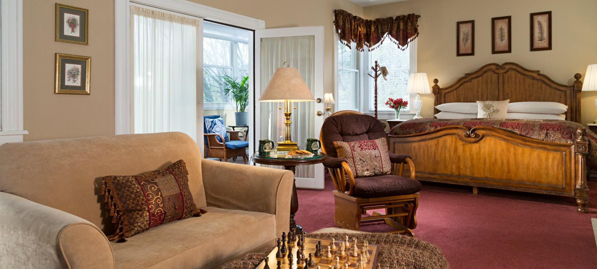 Magnolia suite bedroom and sitting area bedroom with king sized bed and sitting area with glider chair and love seat