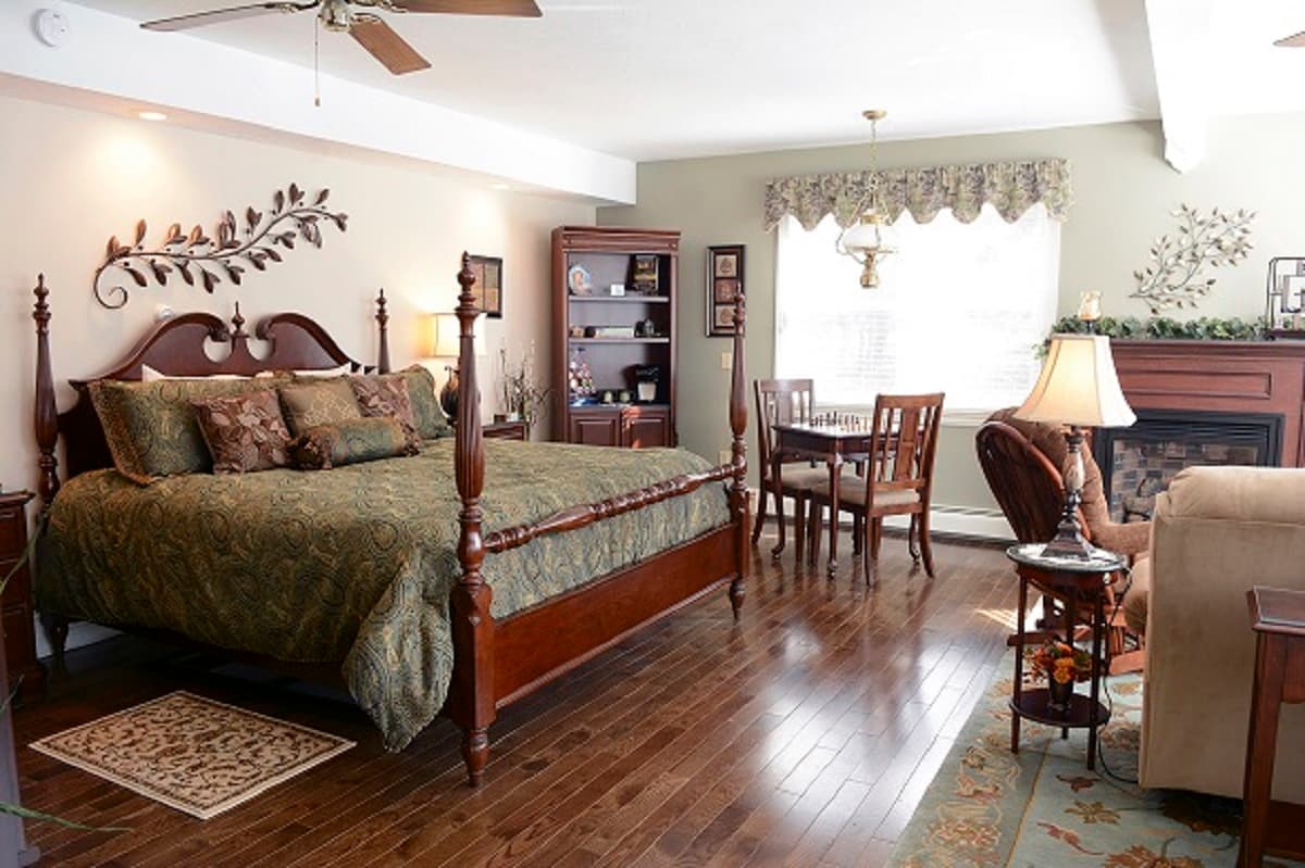 Garden suite bedroom with king size bed and sitting area with TV, glider chair and recliner sofa