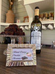 A bottle of olive oil beside a plate of brownies and a framed label that reads "Blood Orange Chocolate Sweets."