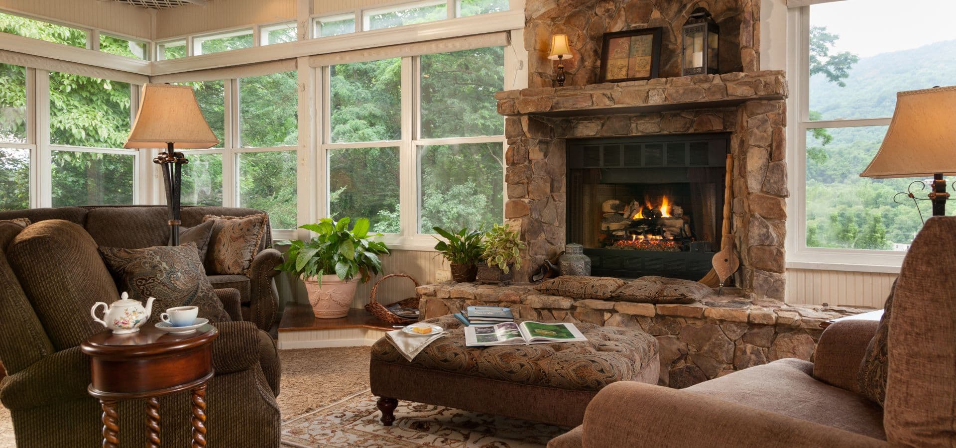 Cozy living room with a stone fireplace, comfortable seating, and abundant natural light.