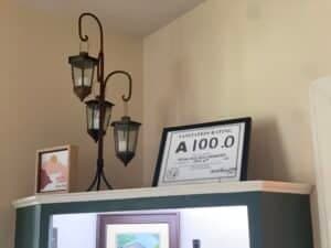 A decorative shelf displaying a framed certificate, a small picture, and three lanterns.
