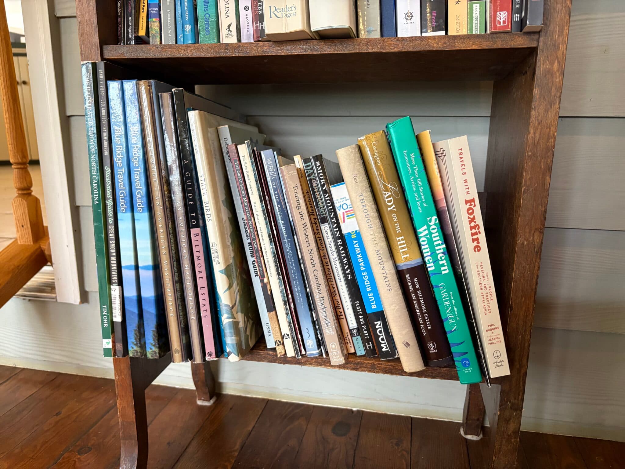 A wooden bookshelf filled with various books, primarily on nature and regional topics. A wooden bookshelf filled with various books, primarily on nature and regional topics.