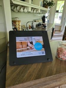 A tablet displaying a promotion for a wine tasting event in a kitchen setting.