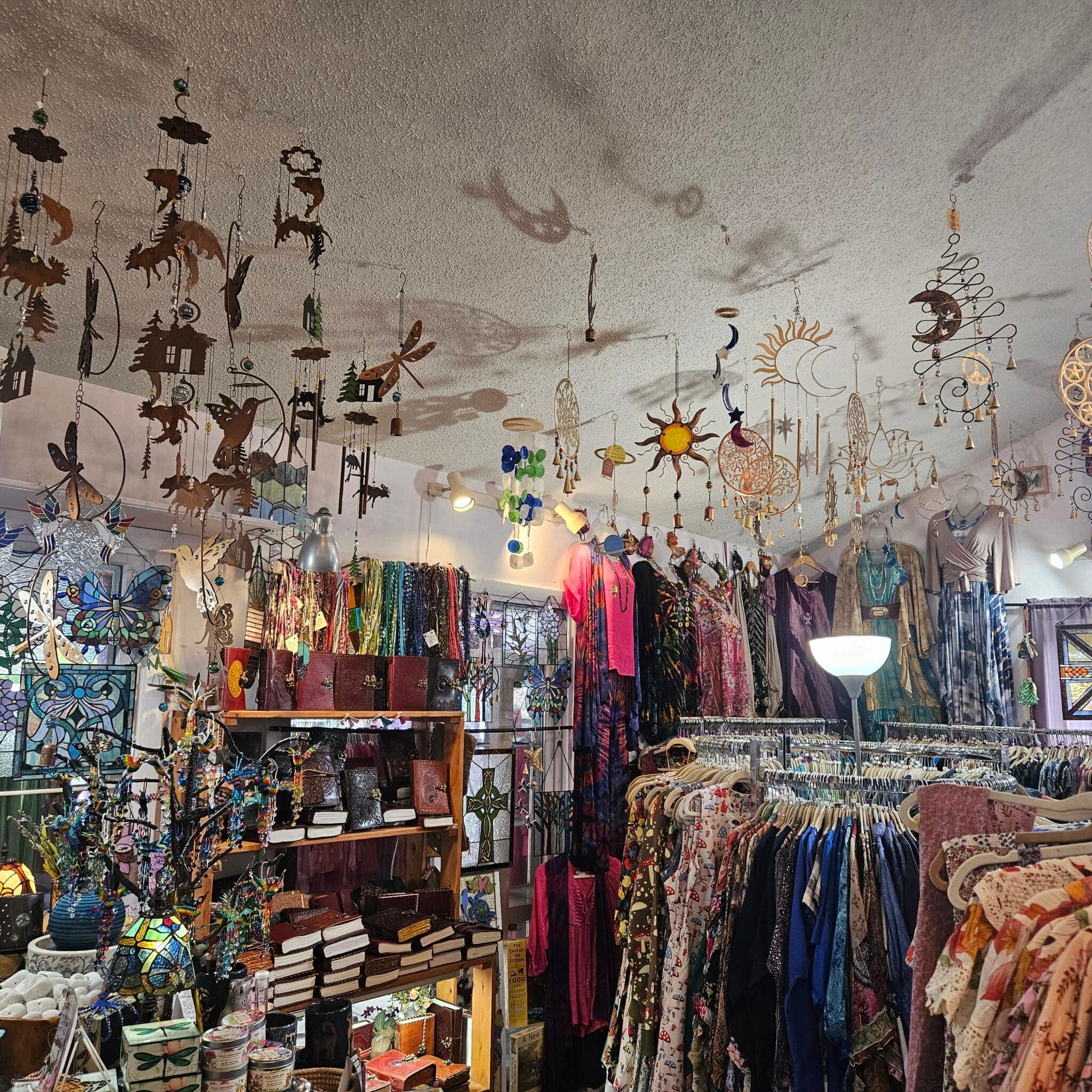 A vibrant shop interior filled with colorful clothing, accessories, and hanging decorative ornaments. A vibrant shop interior filled with colorful clothing, accessories, and hanging decorative ornaments.