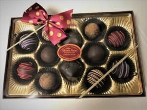 A box of assorted chocolate truffles tied with a decorative ribbon.