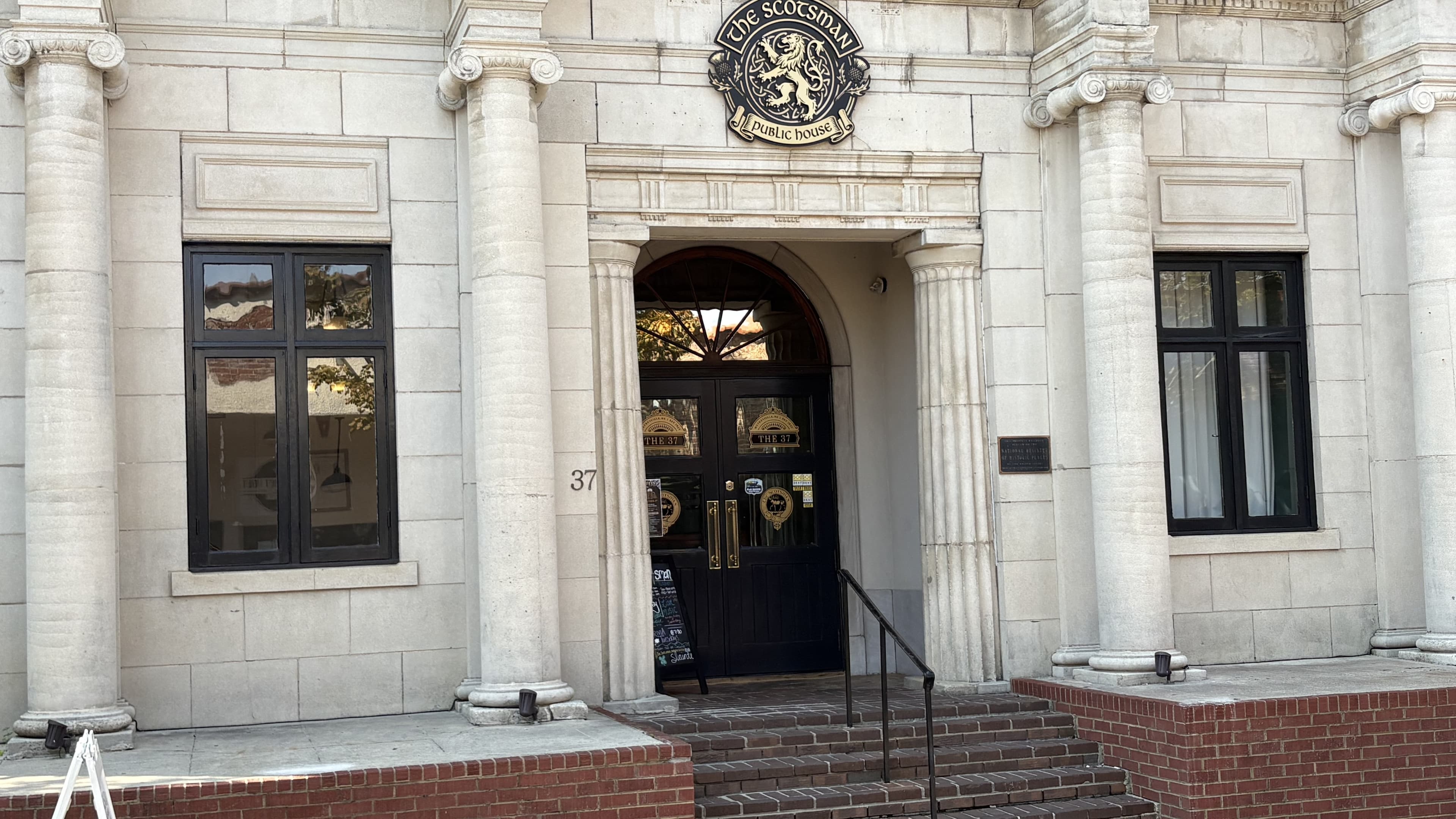 Entrance of a historical building featuring ornate architecture and a decorative sign.