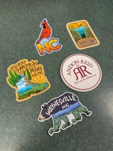 A collection of five colorful stickers featuring designs related to North Carolina and the Great Smoky Mountains.