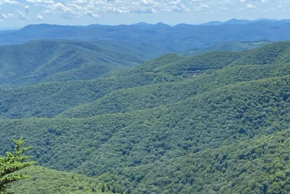 Lush green hills extend into the distance under a partly cloudy sky.