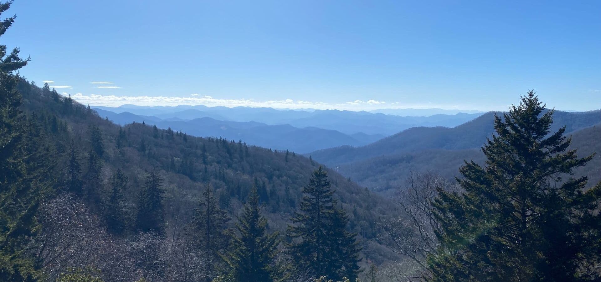 Panoramic view of rolling mountains under a clear blue sky.