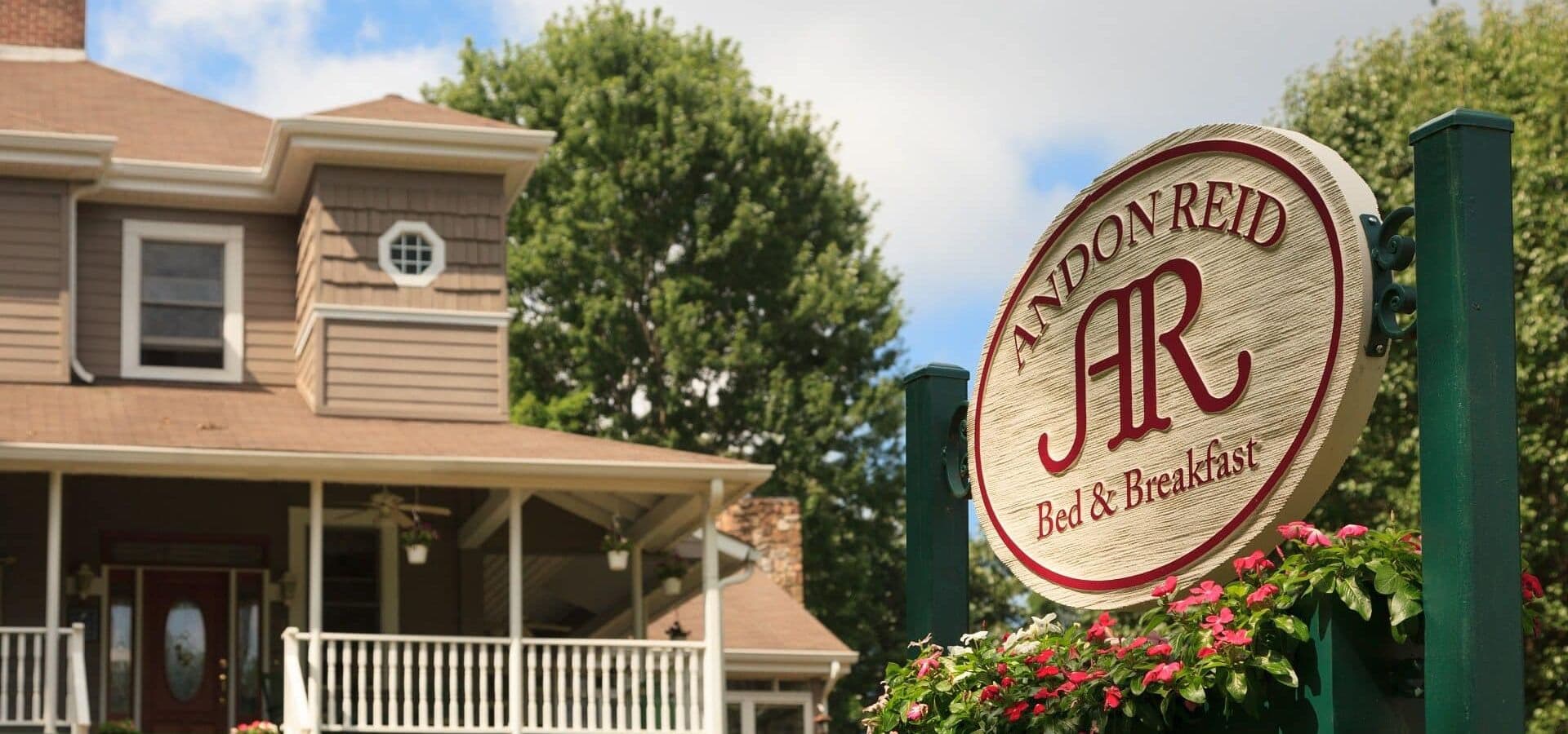 Sign for Andon Reid Bed & Breakfast in front of a cozy home.