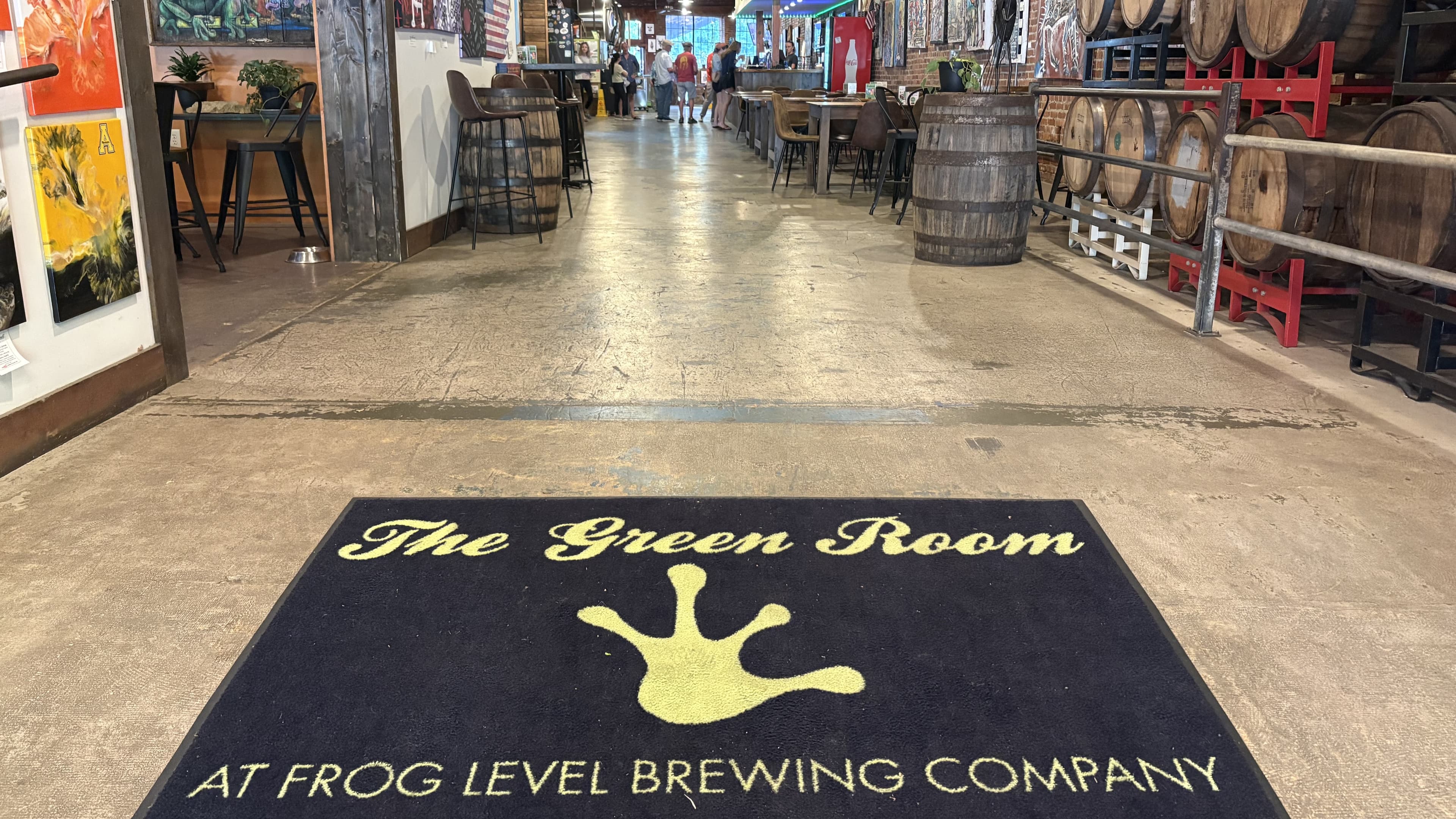 A welcome mat reading "The Green Room at Frog Level Brewing Company" in a spacious brewery interior.