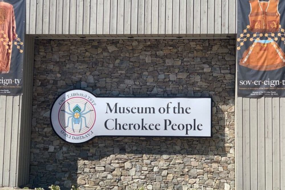 Signage for the Museum of the Cherokee People set against a stone wall.