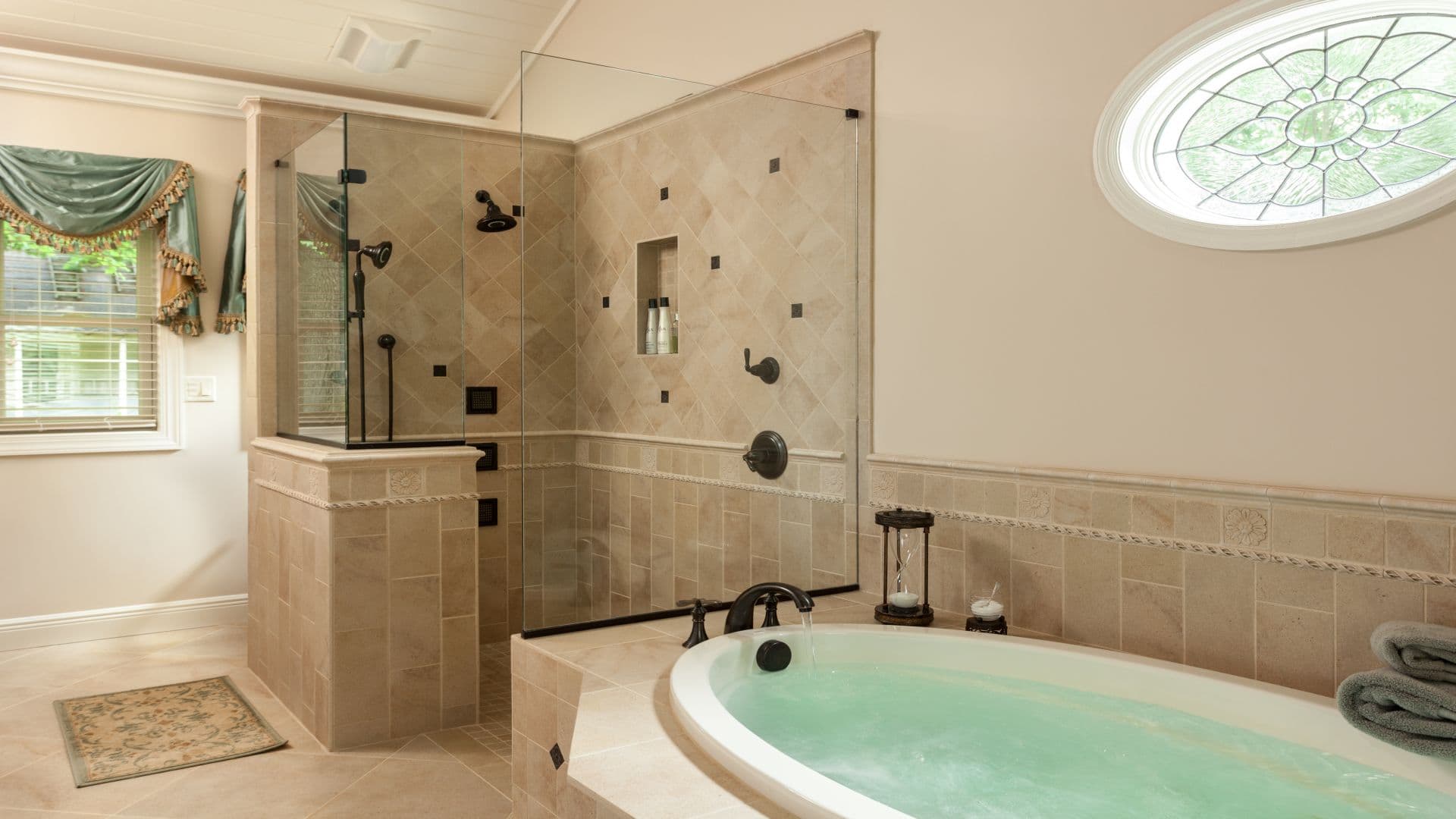 A luxurious bathroom featuring a corner soaking tub and a glass-enclosed shower with stone tile accents.