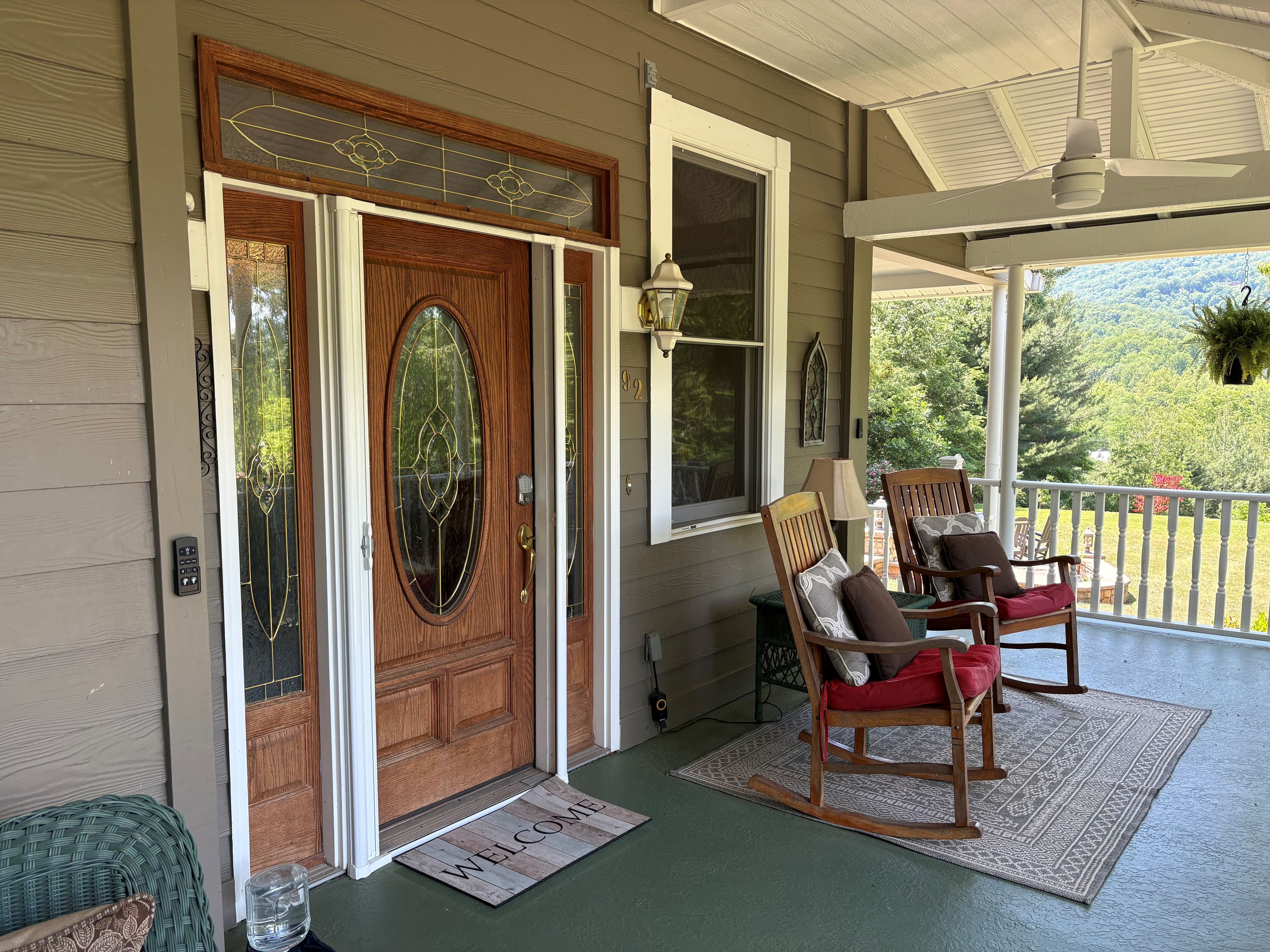 A cozy porch with a wooden door, rocking chairs, and a "WELCOME" mat. A cozy porch with a wooden door, rocking chairs, and a "WELCOME" mat.