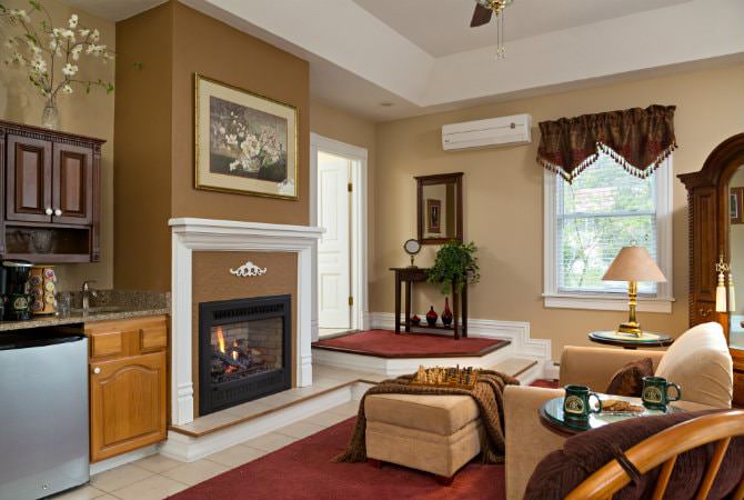 Beautiful tan living room with natural light, fireplace, beverage center, upholstered furniture and floor rugs