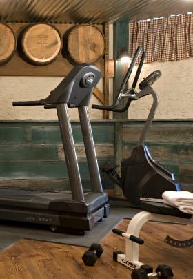 Exercise room with treadmill and stairstepper, wood floors and green horizontal beadboard