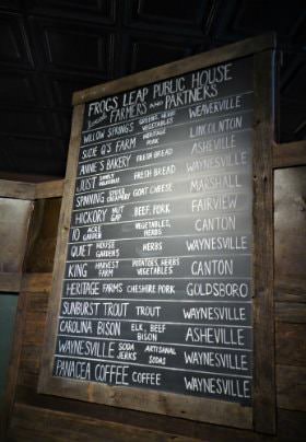 Large chalkboard with menu options written in white chalk and rustic wood frame